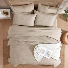 an overhead view of a bed with two pillows and blankets on top of the bed