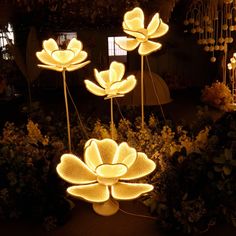 lighted flower sculptures in a garden at night