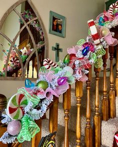 a staircase decorated with christmas decorations and ribbons on the bannister rail, next to a mirror