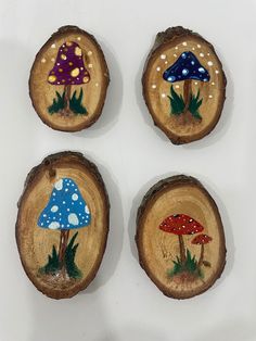 four wood slices with mushrooms painted on them