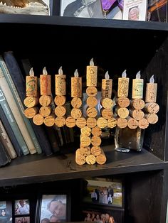 a wooden cross made out of wine corks on a book shelf next to books