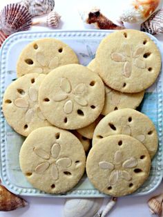 some cookies are sitting on a plate with seashells