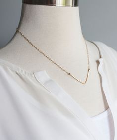 "A delicate hand forged V-shaped pendant gives our Dany Gold Chevron necklace its effortless and modern style - an easy choice for everyday wear. Light hammered texture reflects light from all directions. Looks amazing as a solo delicate piece or layered with your other favorite necklaces. This Signature design is crafted from 100% 14k gold filled wire and chain that will last you for many years to come, and makes a beautiful and affordable gift to yourself or a friend! See another great everyda Bar Necklace Gold, V Necklace, Dainty Necklace Layered, Horseshoe Necklace, Chevron Necklace, Gold Chevron, Gold Bar Necklace, Hammered Gold, Affordable Gifts