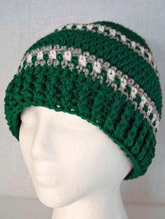 a white mannequin head wearing a green and white knitted beanie hat