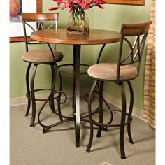 a small table with two stools and a vase full of flowers on the top