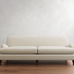 a white couch sitting on top of a hard wood floor