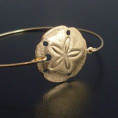 sand dollar Gold Charm Bracelet With Lobster Clasp For Beach, Adjustable Gold Charm Bracelet For The Beach, Beachy Sand-colored Jewelry For Gift, Beachy Sand-colored Jewelry Gift, Adjustable Gold Charm Bracelet Ocean-inspired, Gold Strand Bracelet With Ocean-inspired Style, Adjustable Brass Bracelets For The Beach, Sand-colored Adjustable Bracelet For Gift, Gold Strand Beachy Jewelry