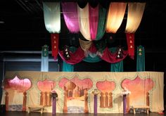 an elaborate stage set up for a performance with colorful drapes and curtains hanging from the ceiling