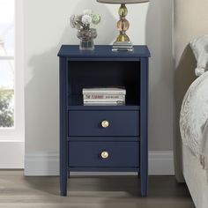 a night stand with two drawers and a lamp