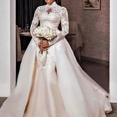 a woman in a wedding dress standing next to a table