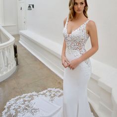 a woman in a white wedding dress posing for the camera with her hand on her hip