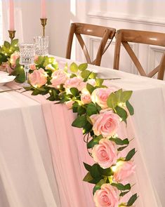 the table is decorated with pink roses and greenery