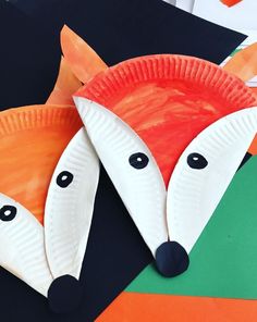 two paper plates shaped like foxes on top of each other, with eyes and noses