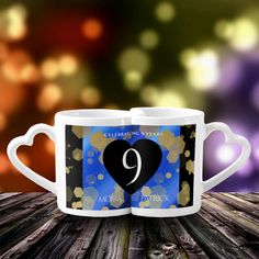 two coffee mugs with the number 9 on them are sitting on a wooden table