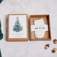 an open box with a christmas card and socks in it, next to some nuts