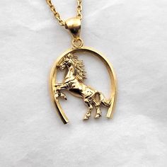 men's horse necklace pendant 1 made in 14k solid gold or 18k solid gold this necklace pendant is a horse with exquisite details in a horse's hoof. - pendant height is 28mm without the bail. - model wears a 2.1mm chain 50cm. - materials: 14k solid gold, 18k solid gold - designed by carre d'or - made in south korea 14k gold horse pendant necklace weight pendant only 7.66g (±5%) with a 2.1mm chain 42cm 13.62g (±5%) with a 2.4mm chain 42cm 15.49g (±5%) with a 3.0mm chain 42cm 19.24g (±5%) 18k gold horse pendant necklace weight pendant only 9.13g (±5%) with a 2.1mm chain 42cm 15.53g (±5%) with a 2.4mm chain 42cm 17.54g (±5%) with a 3.0mm chain 42cm 21.56g (±5%) Gold Horse Design Pendant Necklace, 14k Yellow Gold Jewelry With Horse Design, Gold Pendant Necklace With Horse Design, Classic Horse Design Pendant Necklace, Classic Gold Jewelry With Horse Design, Mens Necklace Gold, Men's Necklace Gold, Heirloom Rings, Horse Pendant