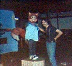 two women standing next to each other in front of a cat costume