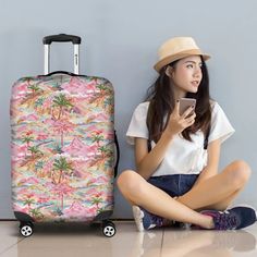 a woman sitting on the floor next to a suitcase and looking at her cell phone