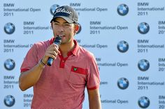 a man holding a microphone in front of a bmw logo wall with the bmw international open written on it