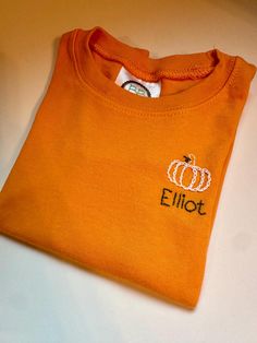 Hand stitched pumpkin toddler t shirt with name.  Font name and color are customizable Hand Embroidered Name, Embroidered Pumpkin, Embroidered Name, Columbia Sc, Kids Tops, Hand Stitched, Hand Stitching, Halloween Shopping, Hand Embroidered