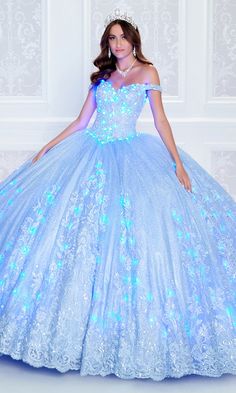 Wear this majestic quinceañera dress, from Princesa by Ariana Vara, for a show-stopping look both day and night. Glimmering beading and stone accents, as well as a voluminous glitter tulle skirt, catch the sun for daytime ceremonies, while matching lights in the bodice and skirt make this glow-in-the-dark quinceañera eye-catching for twilight parties. Glamorous embroidered lace highlights the bodice and wraps around the bottom of the poofy skirt on this quince ball gown. The detachable sleeves o Glowing Dress, Knot Board, Poofy Dresses, Dresses Dark Blue, Poofy Skirt, Quinceanera Themes Dresses, Poofy Dress, Fairytale Gown, Pretty Quinceanera Dresses