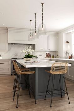 a kitchen with two stools next to an island