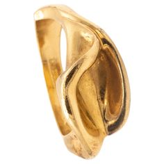 Rare ring designed by Elsa Peretti (1940-2021) for Tiffany & Co. An sculptural free form ring designed by Peretti, back in the 1980's in the shape of a calla lily. Is a beautiful abstraction of the flower, crafted in solid 18 karat of high polished yellow gold. This little sculpture have a reminiscence to the flowers , painted by the American artist women, Georgia O'Keeffe (1887-1986). Have a total weight of 7.94 grams and the actual size is 7, sizable. The top view measures are 22 mm by 11 mm. Stamped, with the maker's mark, the gold assay hallmarks and signed, "TIFFANY & CO. 18 K PERETTI". Elsa Peretti, was a very famous designer that joined Tiffany & Co in the 1974 and change the complete role of diamonds and color gemstones in fashion for the everyday wear and elevating the status of t Hallmarked Modernist Yellow Gold Jewelry, Modernist Hallmarked Yellow Gold Jewelry, Modernist Yellow Gold Rings For Formal Occasions, Modernist Yellow Gold Jewelry For Wedding, Modernist Yellow Gold Wedding Jewelry, Modernist Oval Gold Rings, Modernist Gold Wedding Rings, Collectible Art Nouveau Yellow Gold Ring, Art Nouveau Yellow Gold Collectible Rings