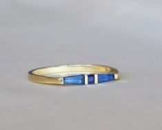 a yellow gold ring with two blue stones