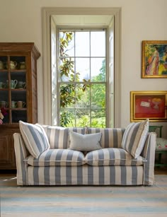 a striped couch sitting in front of a window