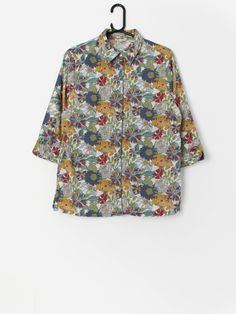 Vintage Y2K floral shirt. This beautiful and vibrant Y2K shirt features an iridescent button closure, three quarter sleeves and a split, flowing hem. Made from a lightweight cotton.  Our recommended size: Medium Label says: 12 Condition: Very good Material: 100% cotton Measurements in inches: Pit to pit: 20 Shoulders: 15.5 Front length: 27.5 Back length: 26.5 Sleeve: 17.5 Hem: 21 We recommend that you compare our measurements to a similar item of your own to ensure good fit. Measurements are tak Multicolor Half-sleeve Blouse For Fall, Spring Patterned Shirt With Relaxed Fit, Patterned Relaxed Fit Shirt For Spring, Patterned Shirt With Relaxed Fit For Spring, Relaxed Fit Patterned Shirt For Spring, Summer Half-sleeve Blouse With Roll-up Sleeves, Summer Tops With Roll-up 3/4 Sleeves, Printed 3/4 Sleeve Blouse, Summer Blouse With 3/4 Roll-up Sleeves