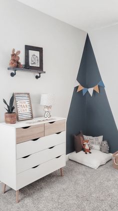 a white dresser sitting next to a wall with a christmas tree on top of it