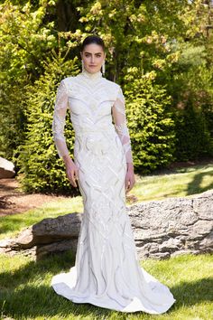 a woman in a white wedding dress standing on grass