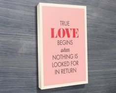 a pink poster hanging on the side of a wooden wall with a quote about love