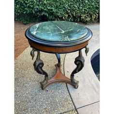 a marble topped table sitting on top of a sidewalk