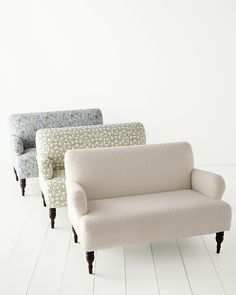 three different colored couches sitting side by side on white floored room with wall in the background