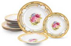 a set of four plates with flowers painted on the front and sides, all in gold trim