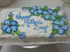 a birthday cake decorated with blue flowers and the words happy mother's day