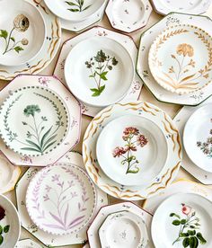 many plates with different designs and flowers on them