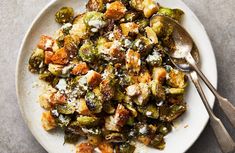 a white plate topped with brussel sprouts covered in parmesan cheese