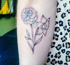 a small flower tattoo on the arm