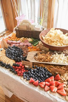 a table topped with lots of different types of food and snacks on top of it