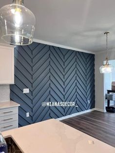 an empty kitchen with blue herringbone wallpaper and wood flooring in the background