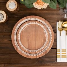 a table setting with gold and white plates, silverware, napkins and flowers