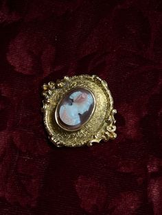 An adornment worthy of a museum! This stunning 19th century Sardonyx Cameo is a testament to Napoleon era French jewelry design. Crafted circa 1850-1860 in 18 carat gold, this brooch features a vibrant cameo of a aristocratic woman, set again a delicate peachy-hued sardonyx mount. The 18-carat gold mounting is also exceptional, with a gilded design brimming with fine detailing, and scrolling foliate motifs. The silhouette it creates makes it feel as if it should be hung in the halls of a palace! Elegant Yellow Gold Baroque Brooches, Victorian Oval Jewelry For Opera, Yellow Gold Baroque Brooch For Formal Occasions, Formal Yellow Gold Baroque Brooches, Luxury Gold Brooches With Cabochon, Elegant Baroque Brooches For Formal Occasions, Vintage Yellow Gold Baroque Brooch, Elegant Formal Brooch With Intaglio Detail, Elegant Cameo Brooch For Formal Wear