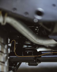 the front end of a vehicle with an exhaust pipe and yellow wire connected to it