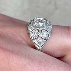 a close up of a person's hand with a diamond ring on their finger