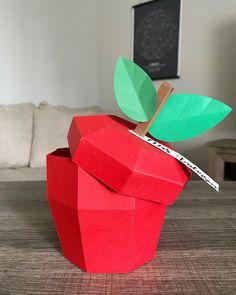 an apple made out of paper sitting on top of a table