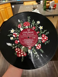 someone holding up a record with flowers on it