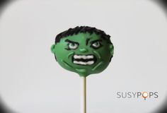 a close up of a green lollipop with a creepy face on it's stick