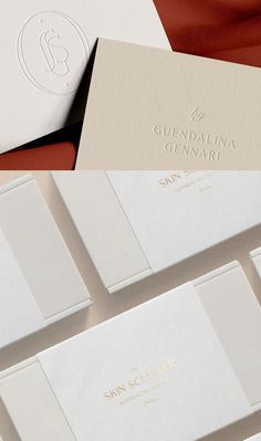 several white and gold business cards on top of each other, with the letter g